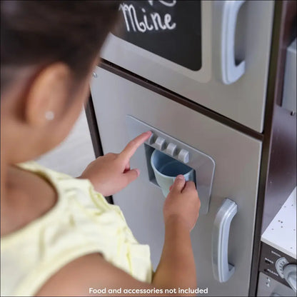 Toy cocina KidKraft con un niño interactuando con el refrigerador de juguete