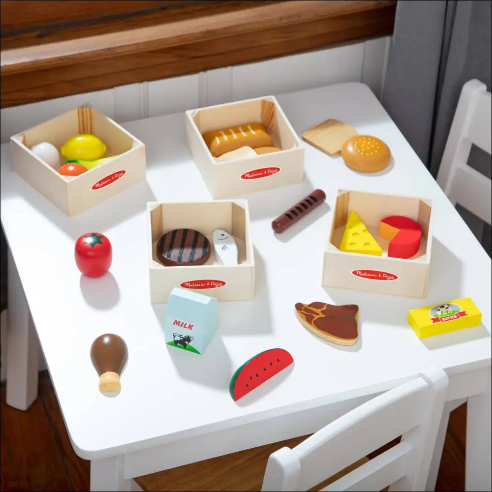 Set de comida de madera Melissa & Doug con variados alimentos en mesa blanca