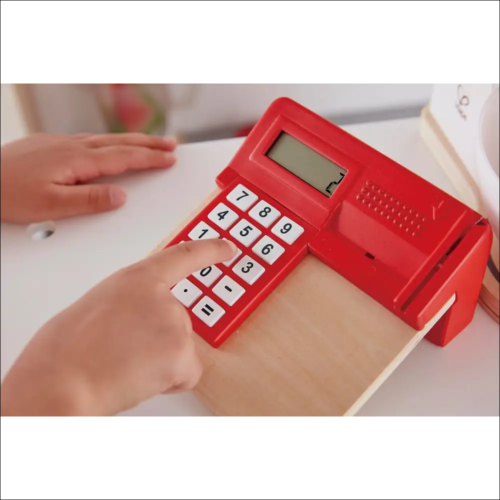 Calculadora roja brillante con botones blancos en Tienda Pop-Up Hape para cocinitas de madera