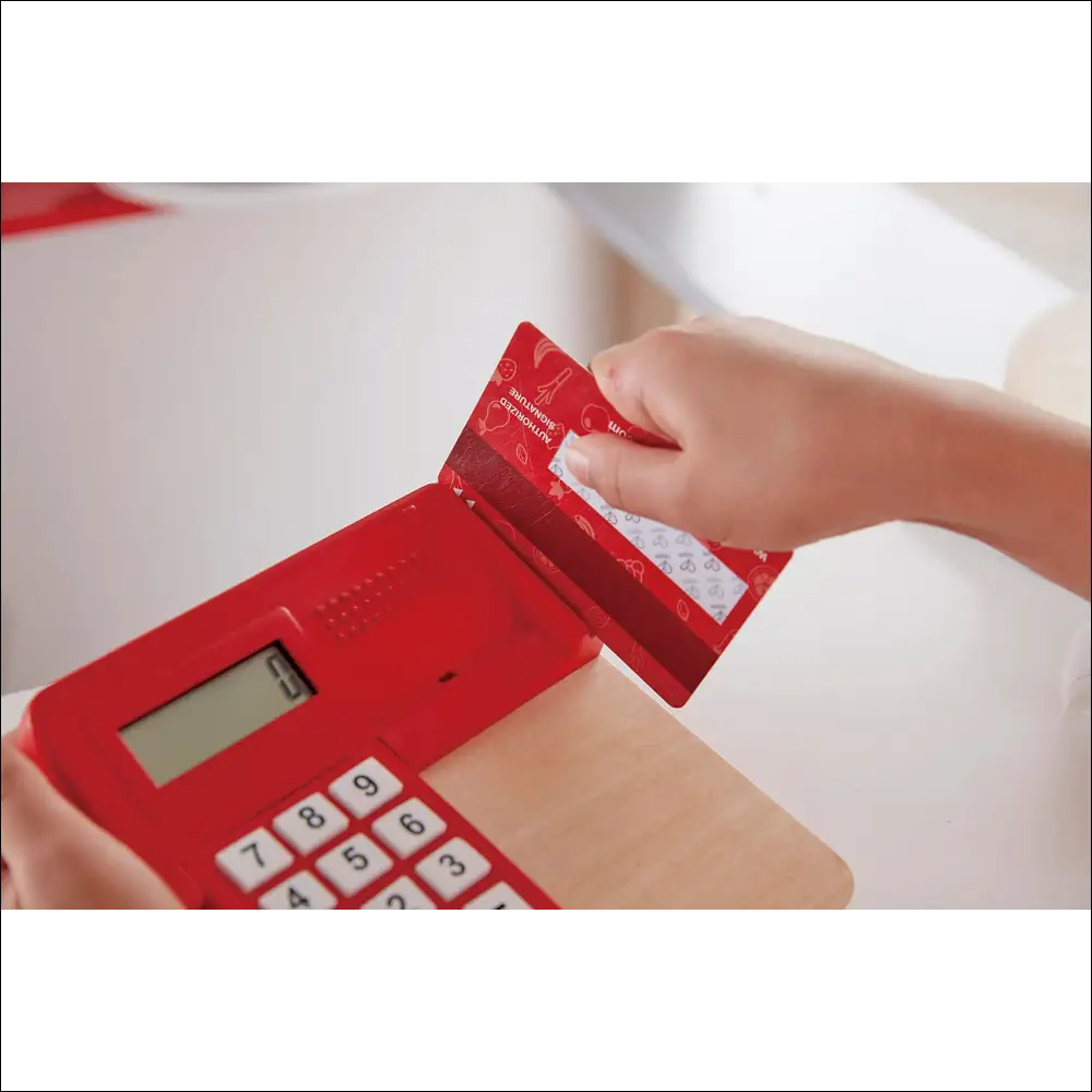 Calculadora roja con tarjeta de crédito en Tienda Pop-Up Hape para cocinitas de madera